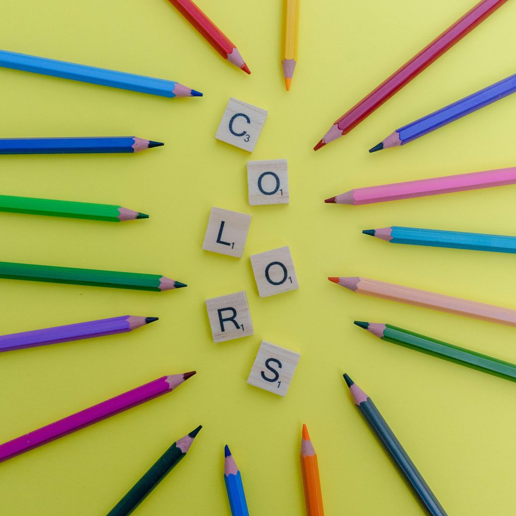 Course Arrangement of multicolored pencils and Scrabble letters on a yellow background.